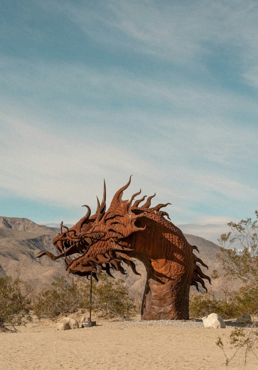 a statue of a dragon in the middle of a desert